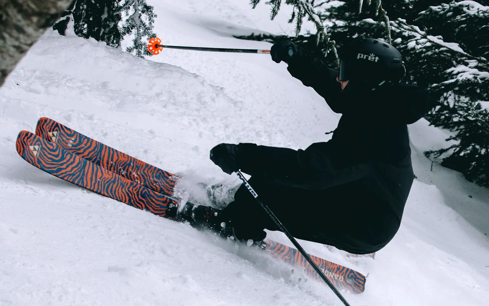 Skier on the Ranger LTD tiger-stripe skis in deep powder
